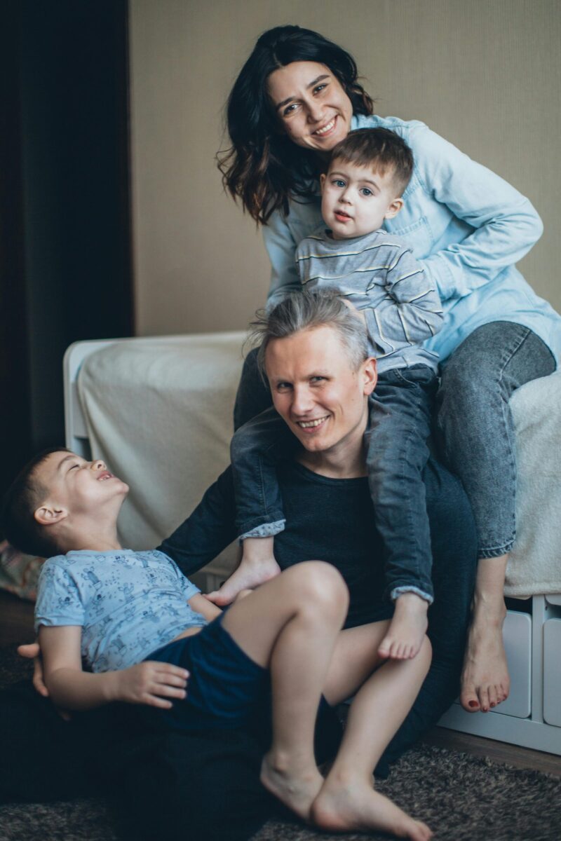 A joyful family of four having fun and bonding indoors, capturing love and togetherness.